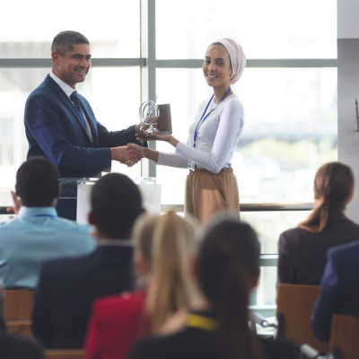 A woman recieving an award in fron of an audience