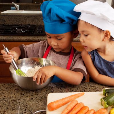 two young children cooking together