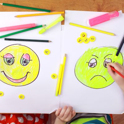 child drawing smily and grumpy faces