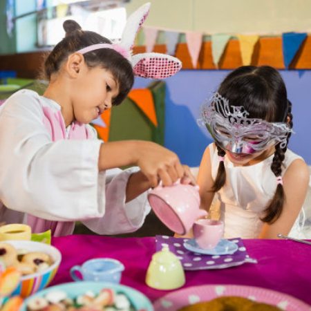 Young girls playing at having a tea party