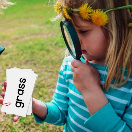 young child looking at word cards